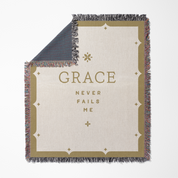 Blanket with 'GRACE NEVER FAILS ME' text on a white background