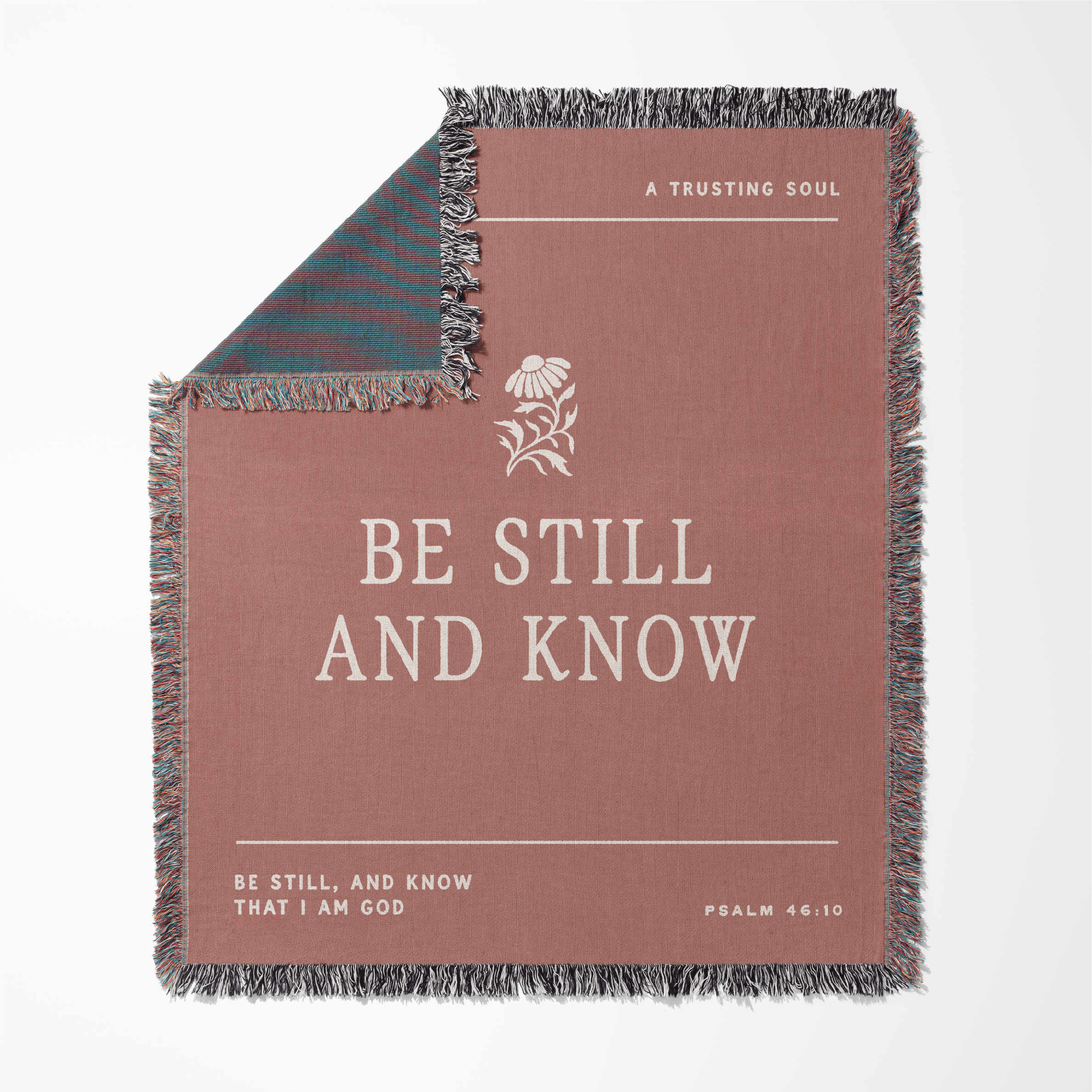 Blanket with 'Be Still and Know' text and design on a white background