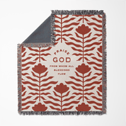 Decorative throw blanket with red floral pattern and text on a white background