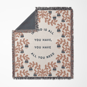 Decorative throw blanket with floral pattern and motivational quote on a white background