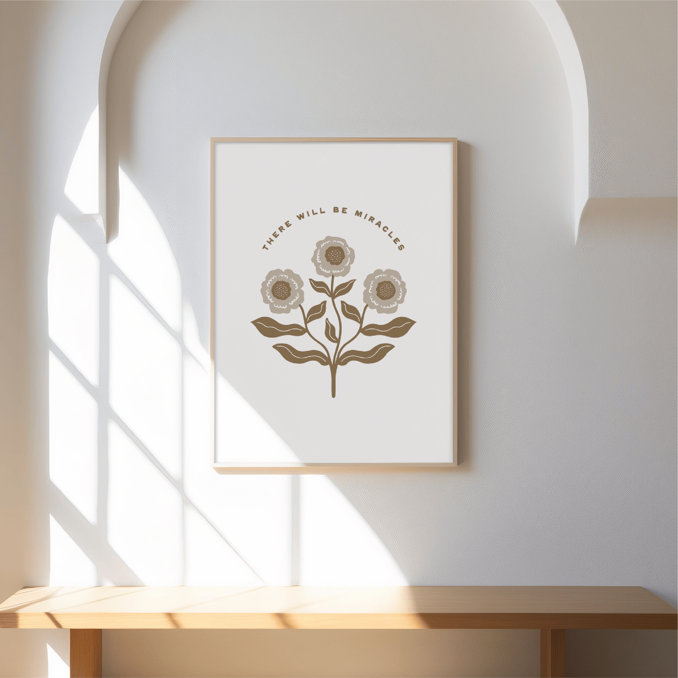 Framed artwork with floral design and text on a wall with sunlight casting shadows.