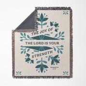 Blanket with 'The Joy of the Lord is Your Strength' text and floral design on a white background