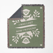Green blanket with floral design and text 'I was lost now I'm found' on a white background