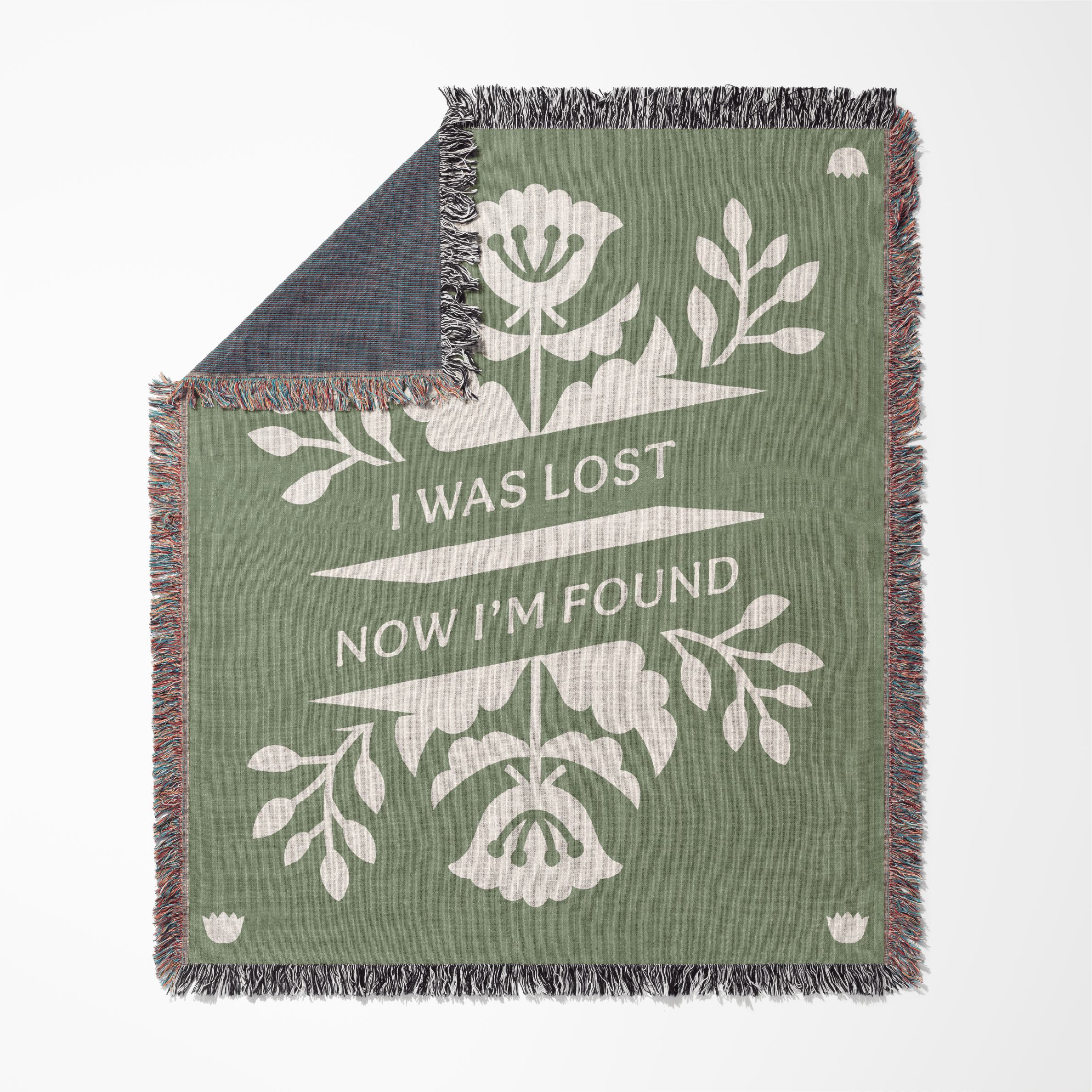 Green blanket with floral design and text 'I was lost now I'm found' on a white background