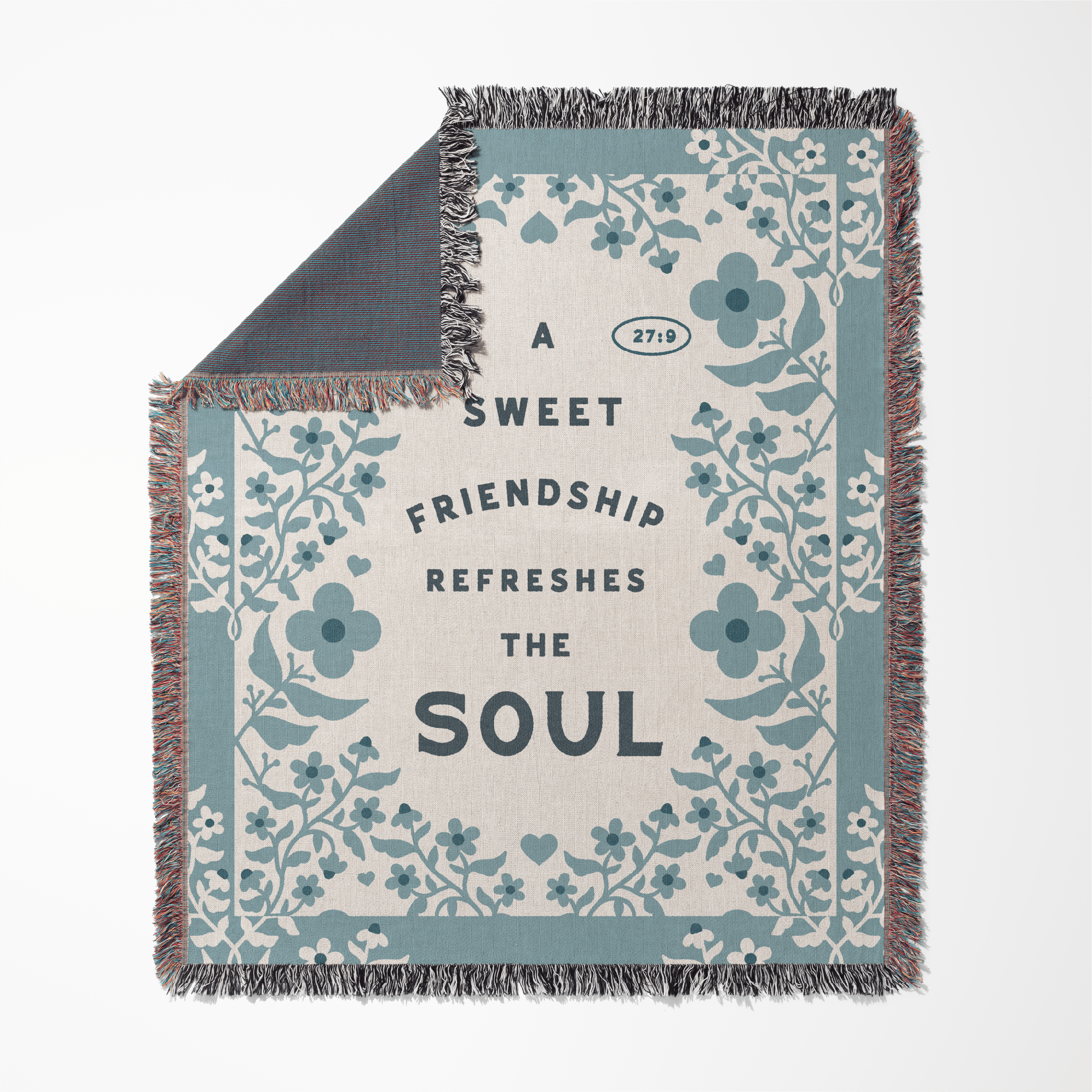Floral-patterned blanket with text 'A sweet friendship refreshes the soul' on a white background
