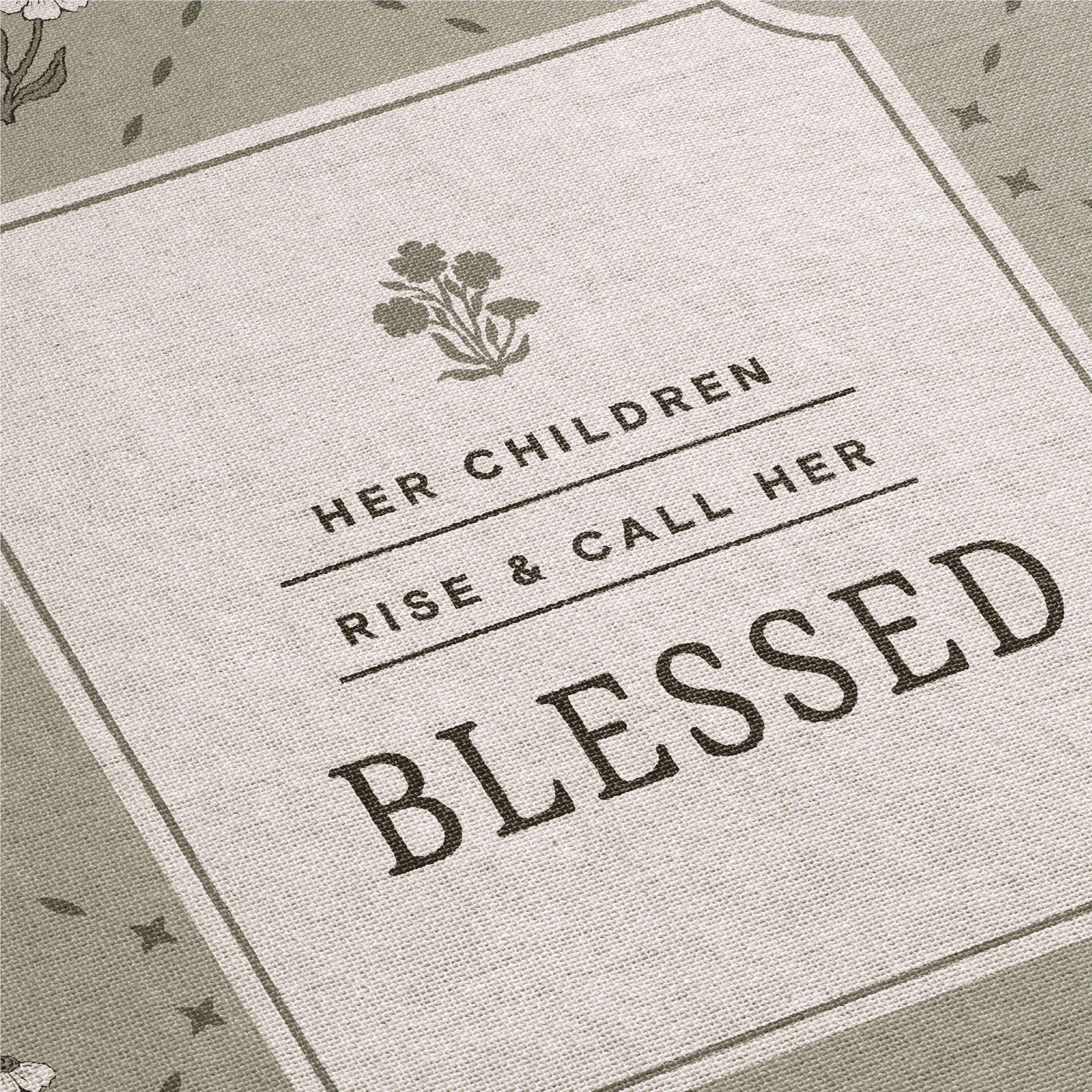 Textile with 'Her children rise and call her blessed' quote and floral design.