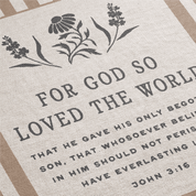 Textile with floral design and Bible verse 'For God so loved the world' on a beige background