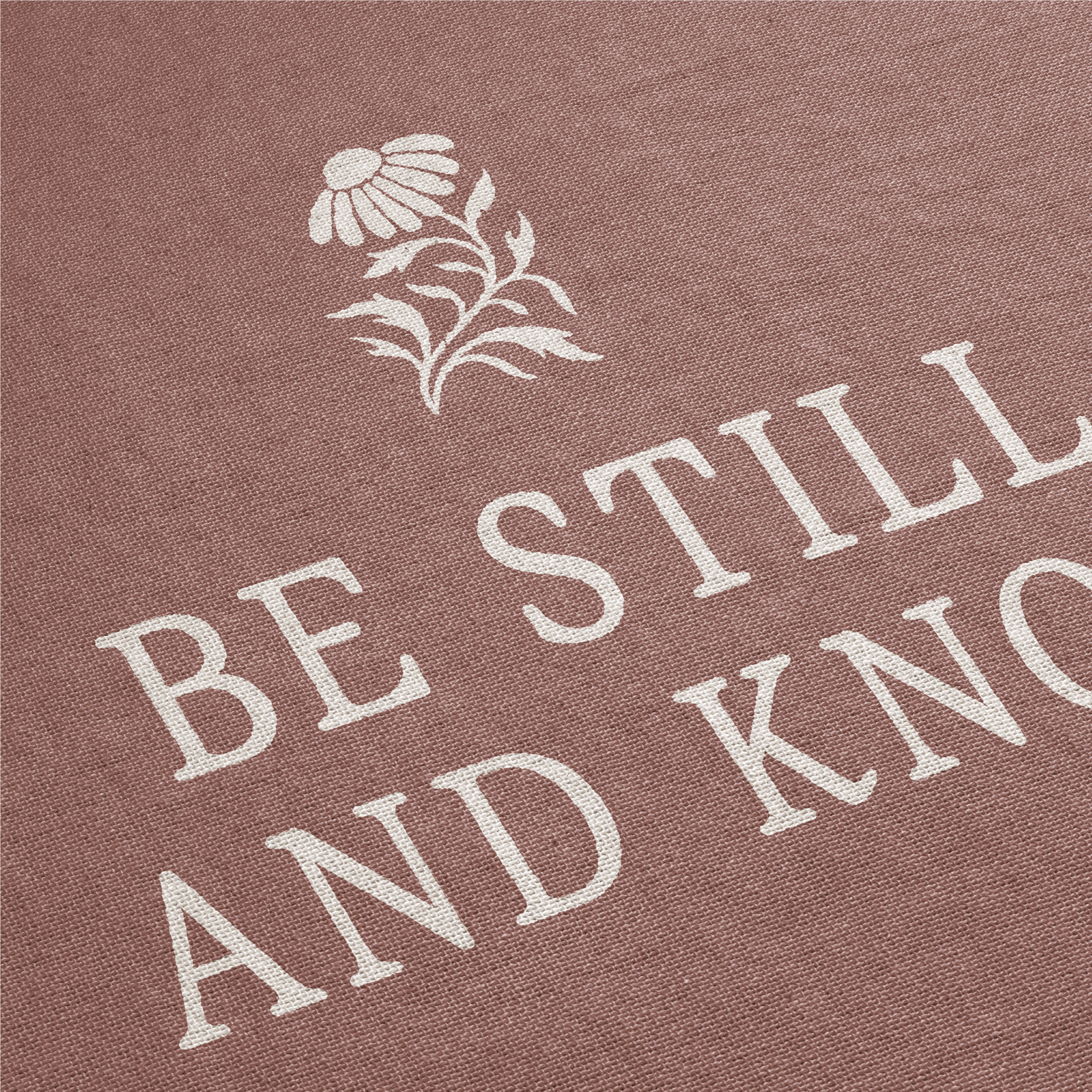 Text 'Be Still and Know' with a flower design on a brown background