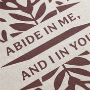Text 'Abide in me, and I in you' with leaf patterns on a beige background
