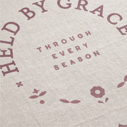 Text 'HELD BY GRACE THROUGH EVERY SEASON' with floral designs on a textured background