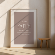 Framed poster with 'Walk by Faith, Not by Sight' quote on a wall with a wooden stool.