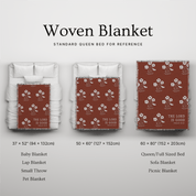 Woven blanket with floral pattern and 'The Lord is Good' text, shown on a bed for reference.