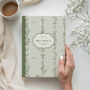 Book titled 'Pray About It' with a hand holding a white flower, cup of coffee, and beige fabric on a light background