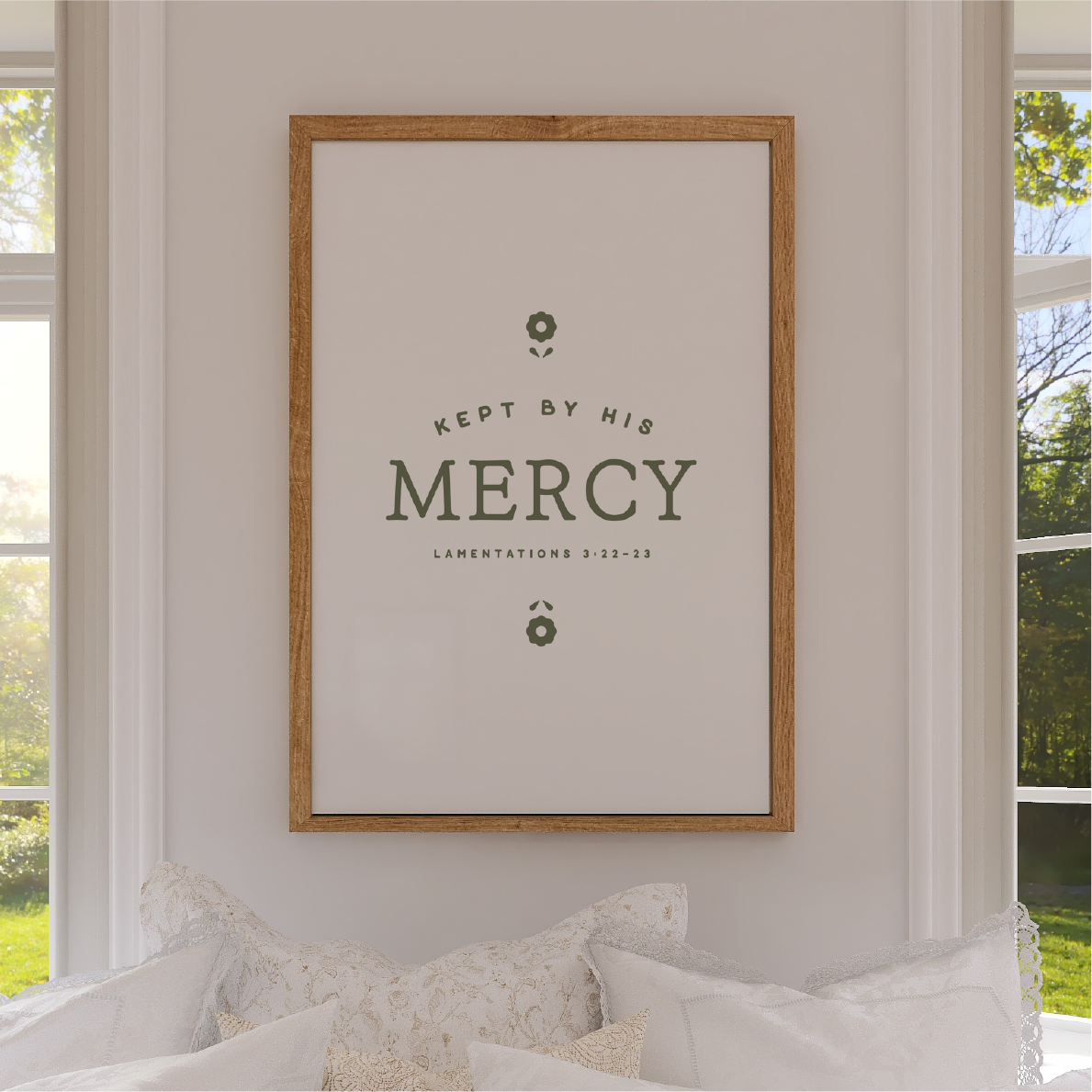 Framed artwork with 'Kept by His Mercy' text on a wall in a room with windows.