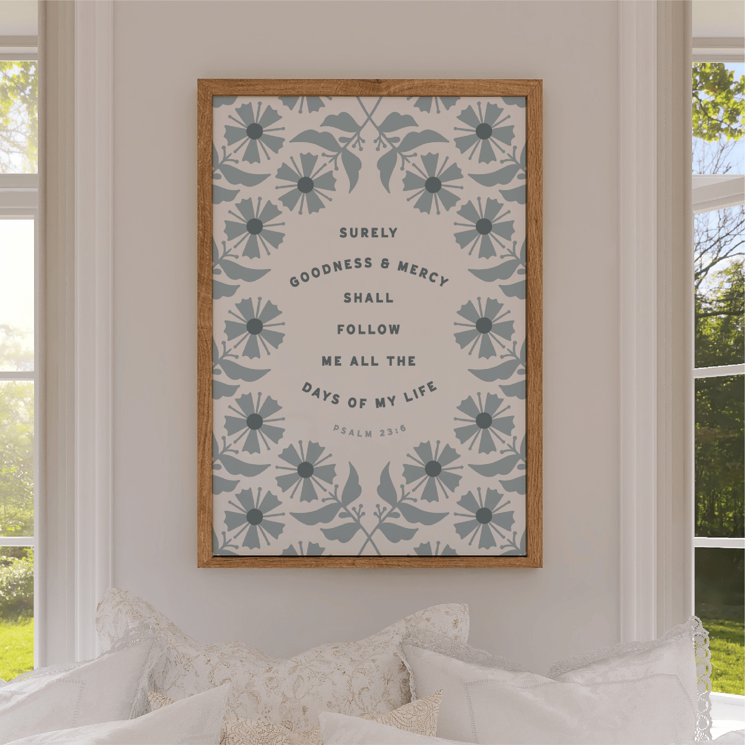 Framed artwork with floral design and text on a wall in a room with windows.