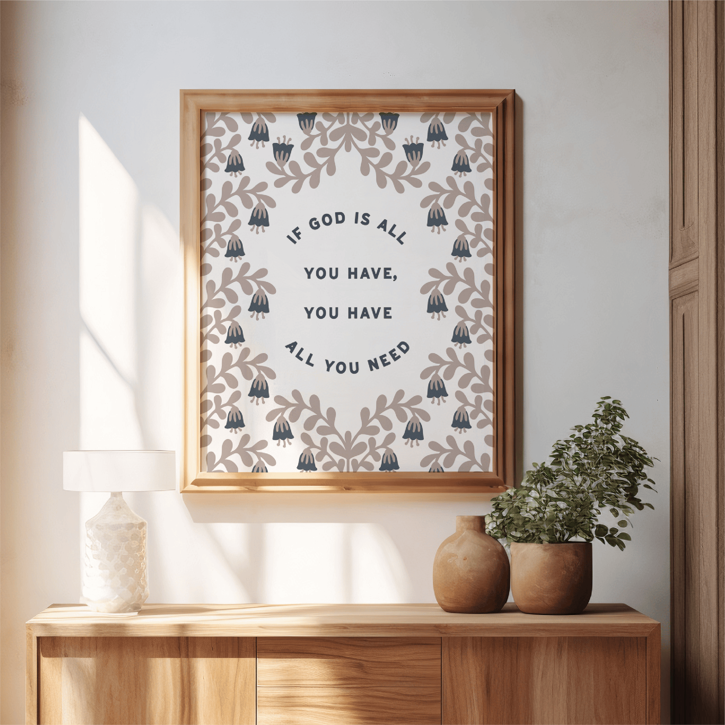 Framed artwork with motivational quote on a wall above a wooden console table with decorative vases and plants.