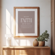 Framed print with 'Walk by Faith, Not by Sight' quote on a wall above a wooden console table.