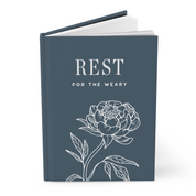 Book with 'REST FOR THE WEARY' text and floral design on a white background