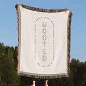 Blanket with text design held up against a natural background