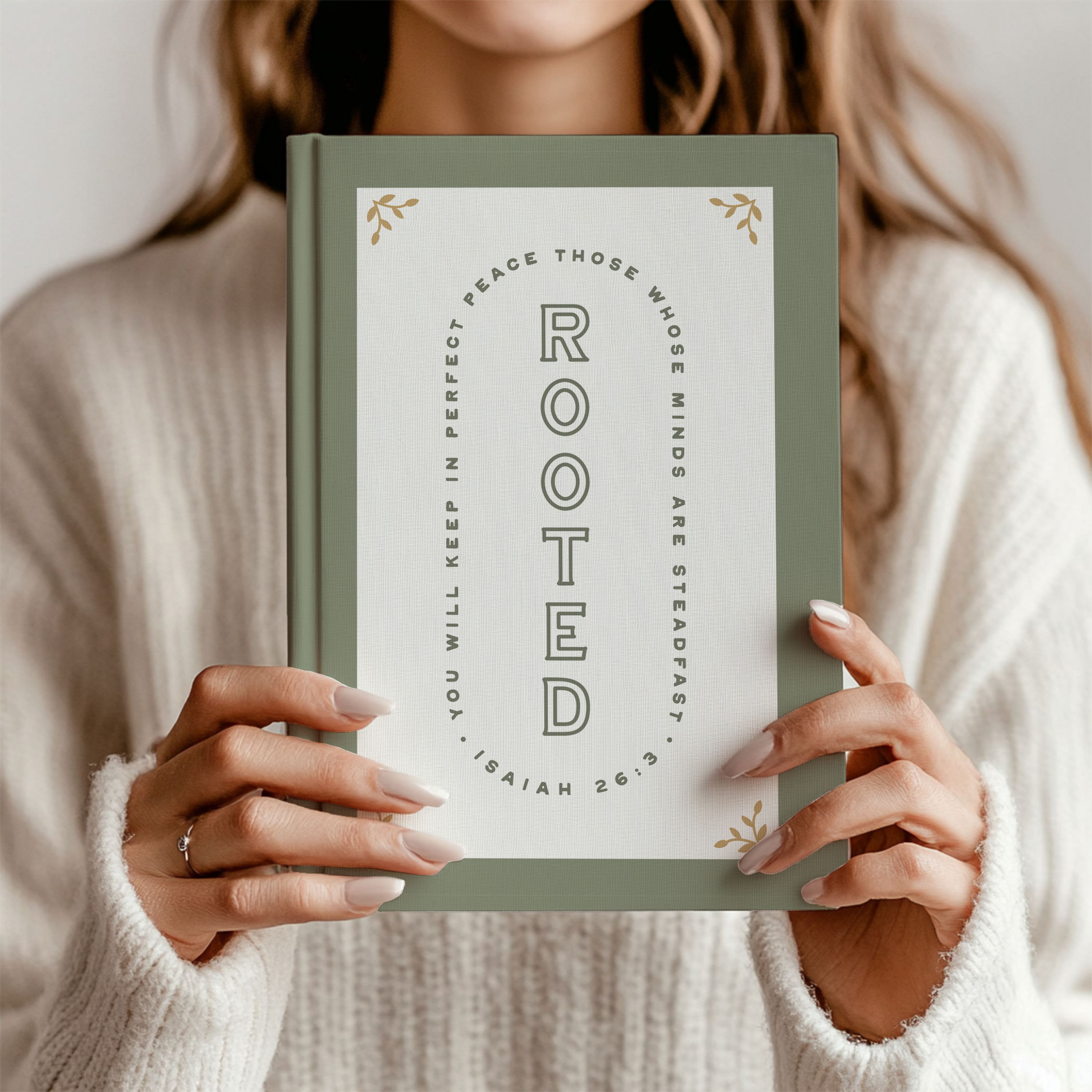 Person holding a book titled 'Rooted' with a motivational quote on the cover.