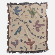 Blanket with bird patterns and text on a beige background