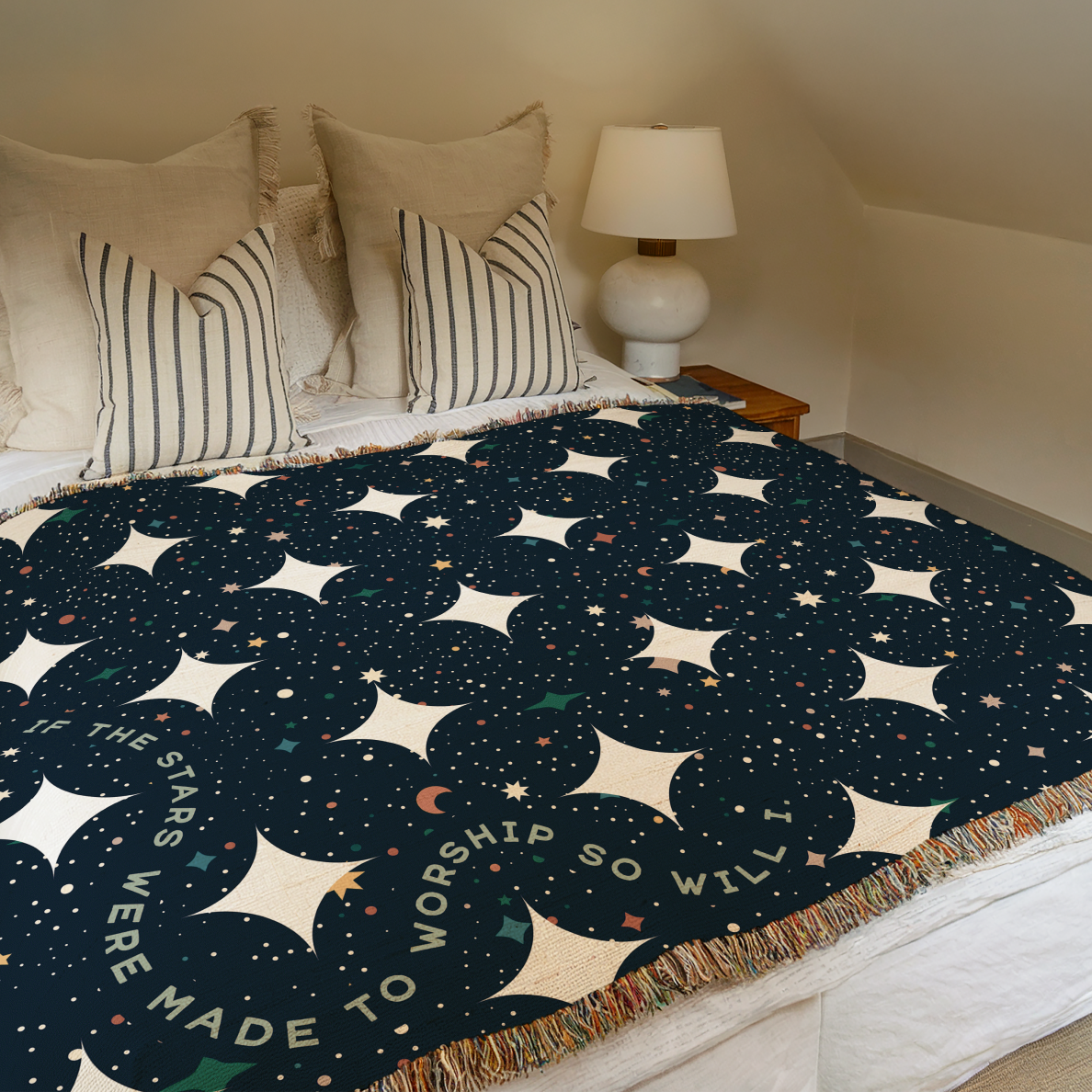 Bed with a star-patterned blanket and pillows in a bedroom setting.