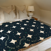 Bed with a star-patterned blanket and pillows in a bedroom setting.