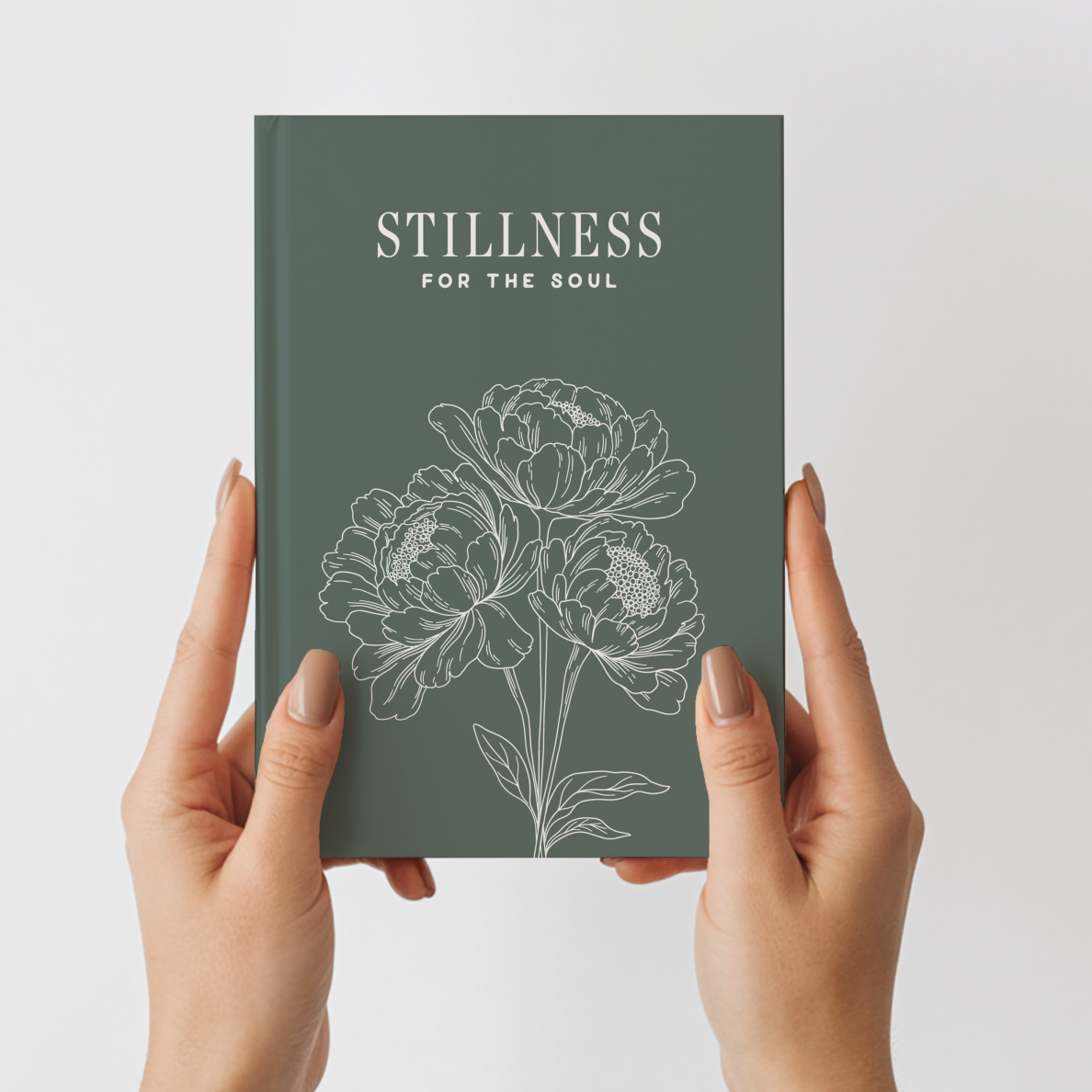 Book titled 'Stillness for the Soul' held by hands against a light gray background