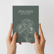 Book titled 'Stillness for the Soul' held by hands against a light gray background