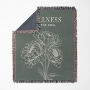 Green blanket with floral design and 'Wellness The Soul' text on a white background
