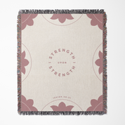 Blanket with floral patterns and 'Strength Upon Strength' text on a white background
