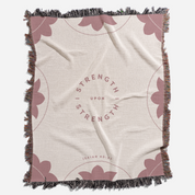 Blanket with 'Strength Upon Strength' text and butterfly designs on a beige background
