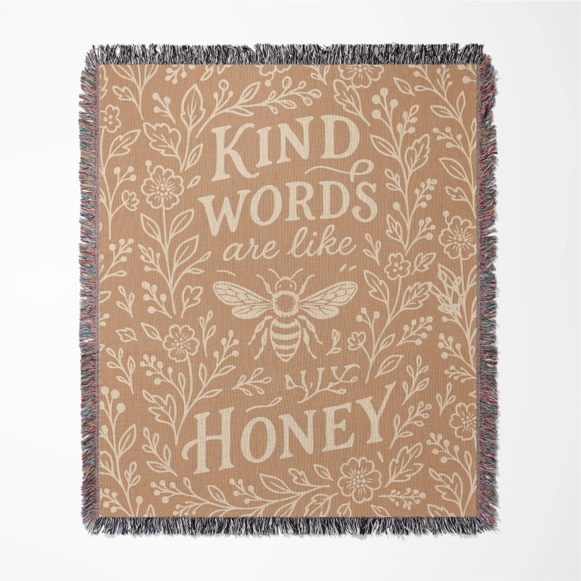 Warm-toned woven blanket with the phrase “Kind words are like honey,” floral accents, and a honey bee; 100% cotton with fringe, perfect for Christian gifting and home decor.