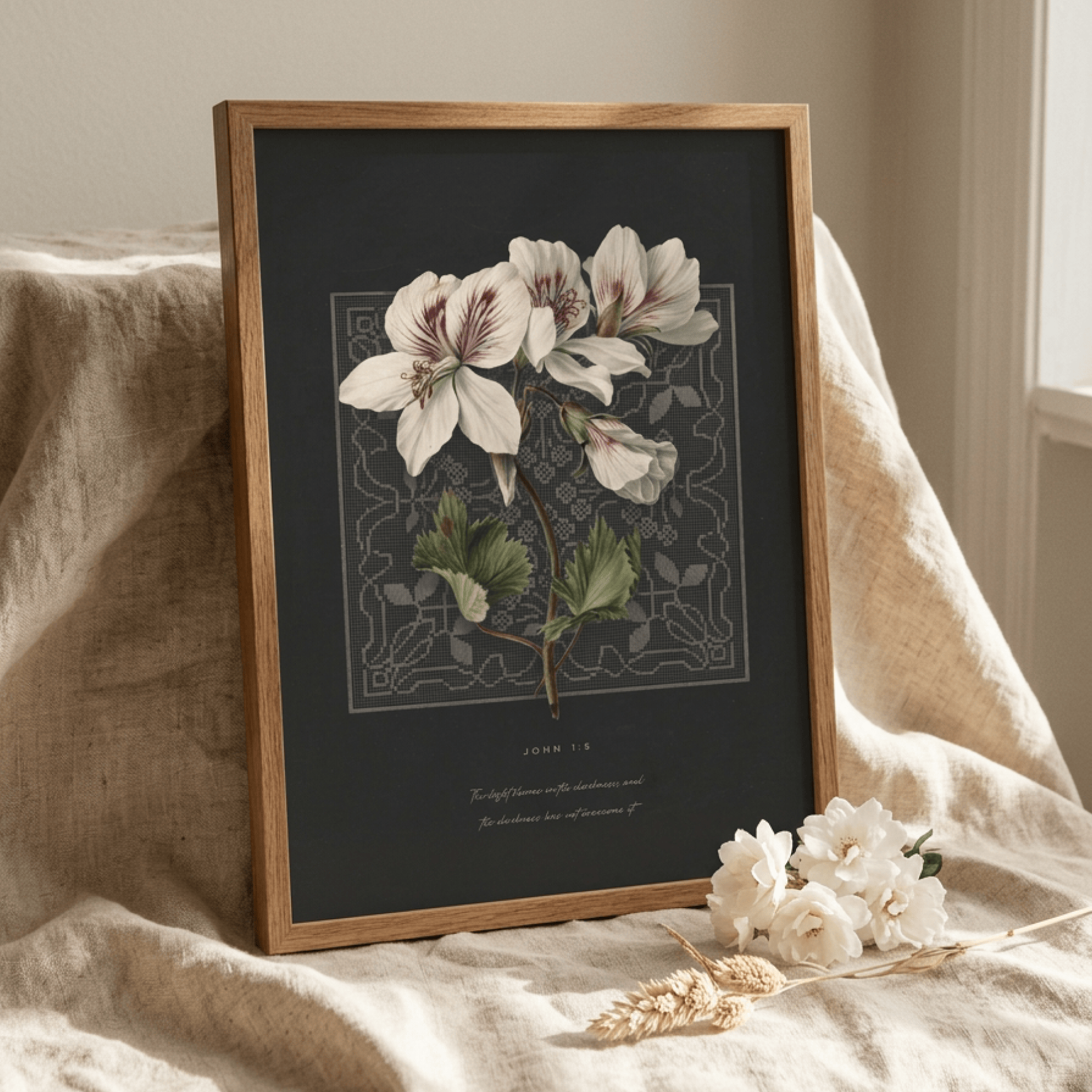 John 1:5 print in a wood frame resting on linen with dried flowers — bible verse wall decor styled setting