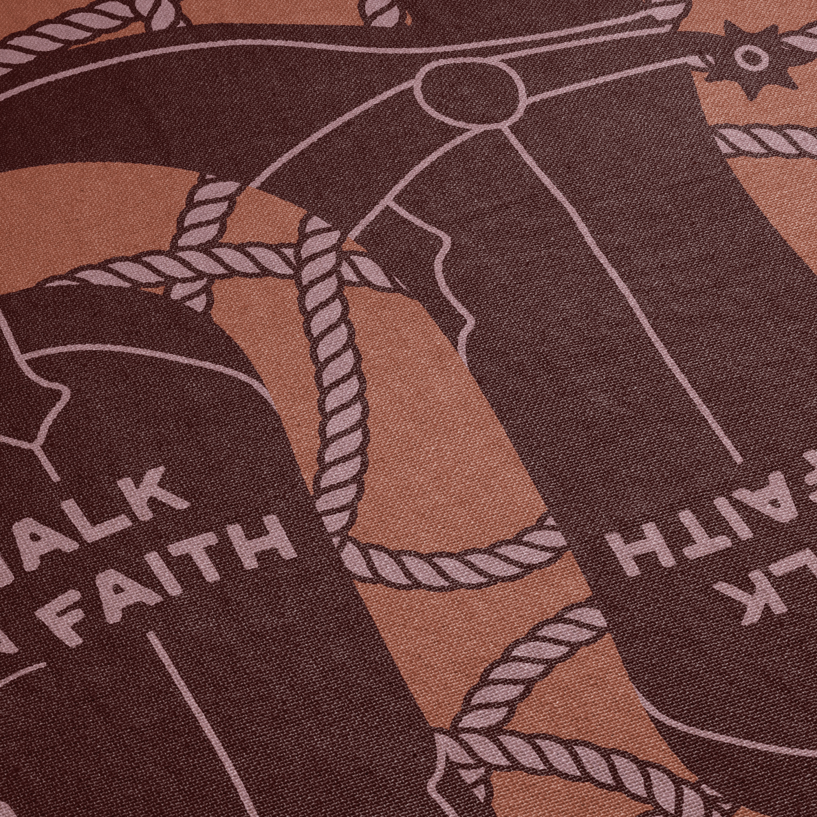 Close-up of a fabric with a design of boots and 'Walk by Faith' text on a brown background.