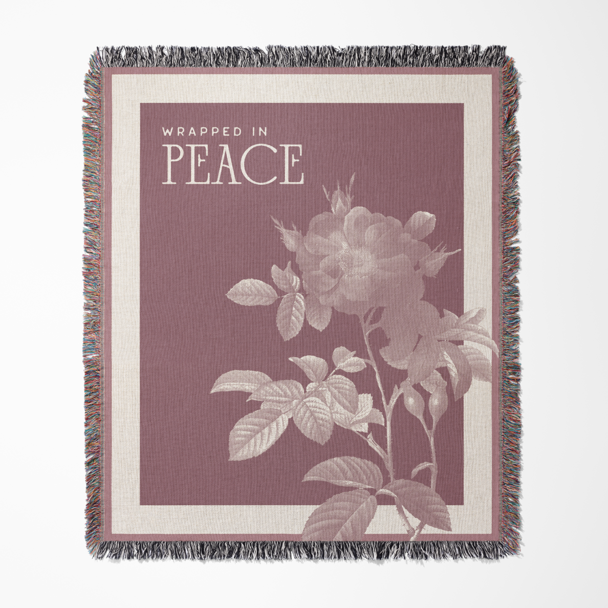 Blanket with floral design and 'Wrapped in Peace' text on a maroon background