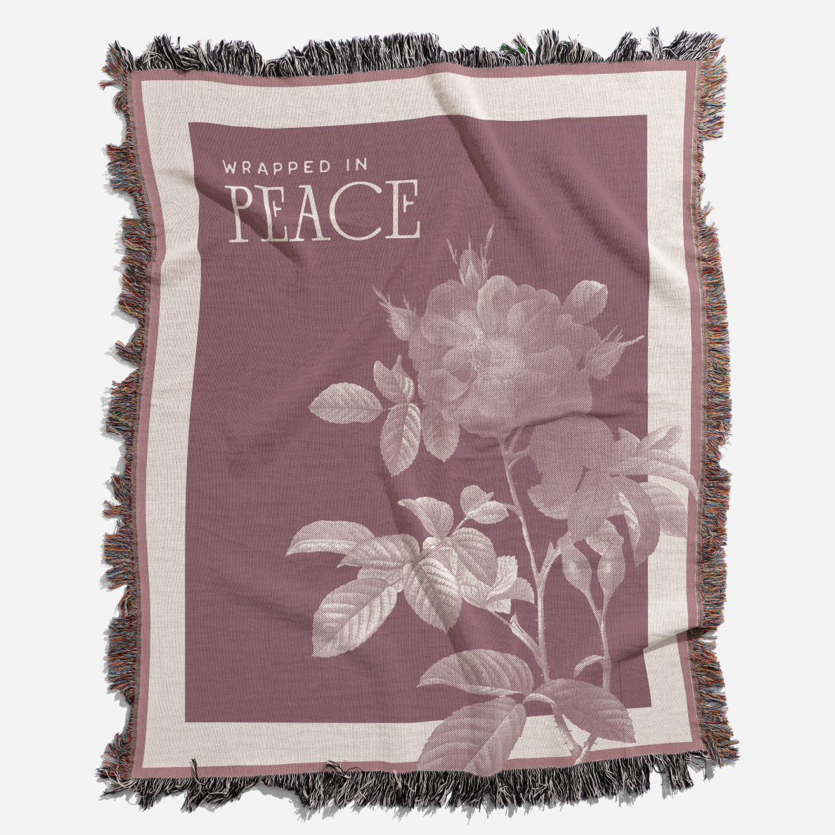 Blanket with floral design and 'Wrapped in Peace' text on a white background