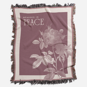 Blanket with floral design and 'Wrapped in Peace' text on a white background